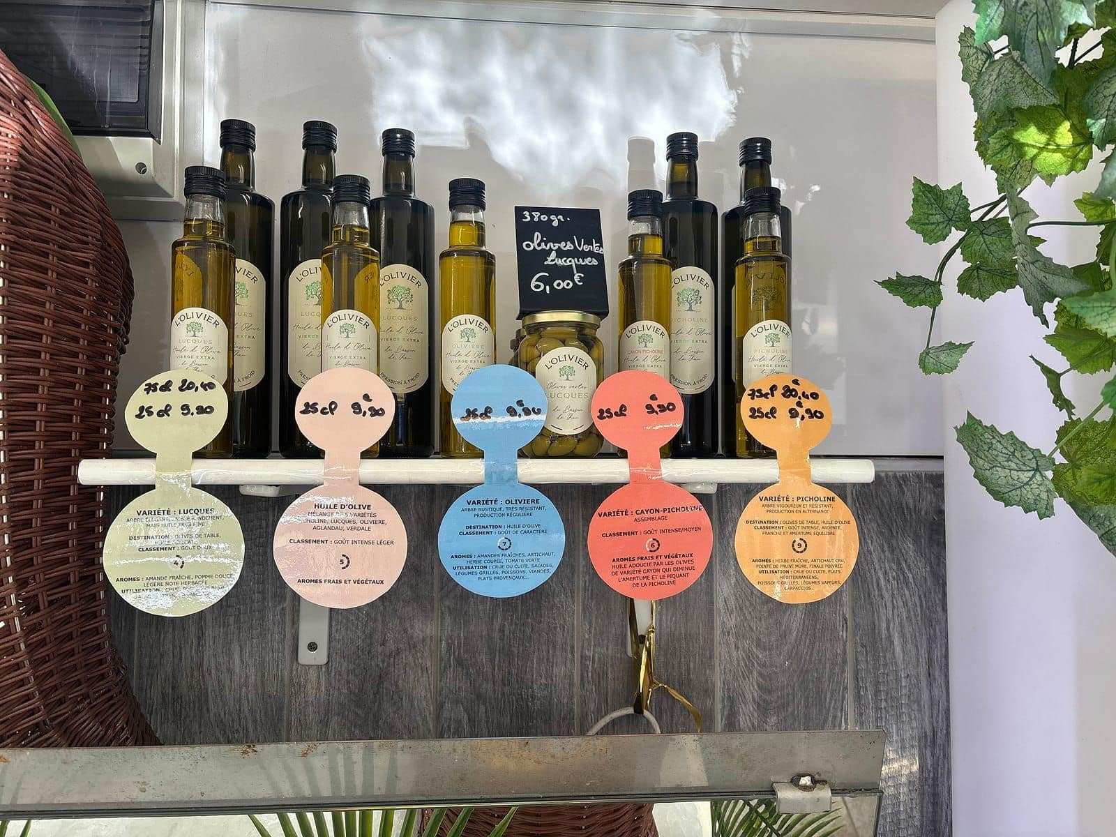 Bouteilles d'huile d'olive et bocal d'olives Lucques sur une étagère du magasin